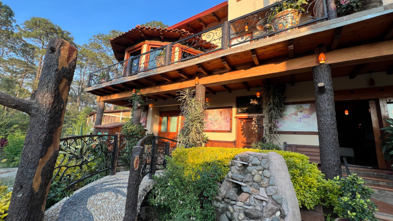 Una casa grande con un balcón y un puente enfrente.