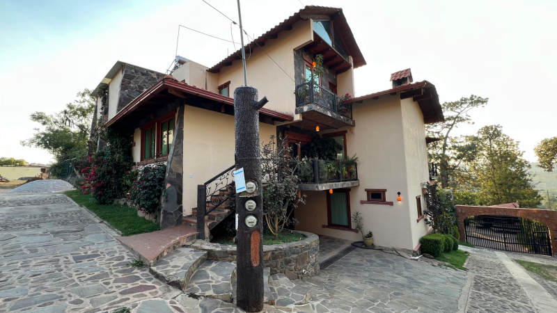 Una casa grande con un poste de madera al frente.