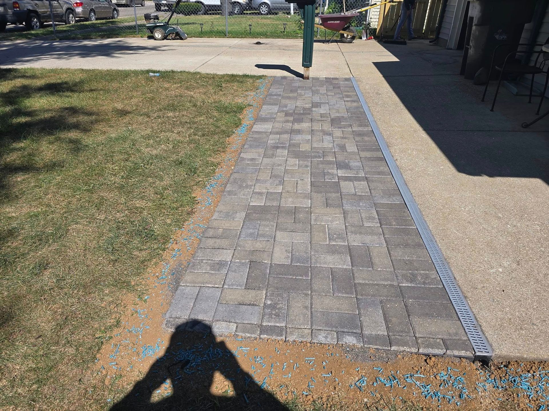 Stone paver walkway next to grass and concrete.