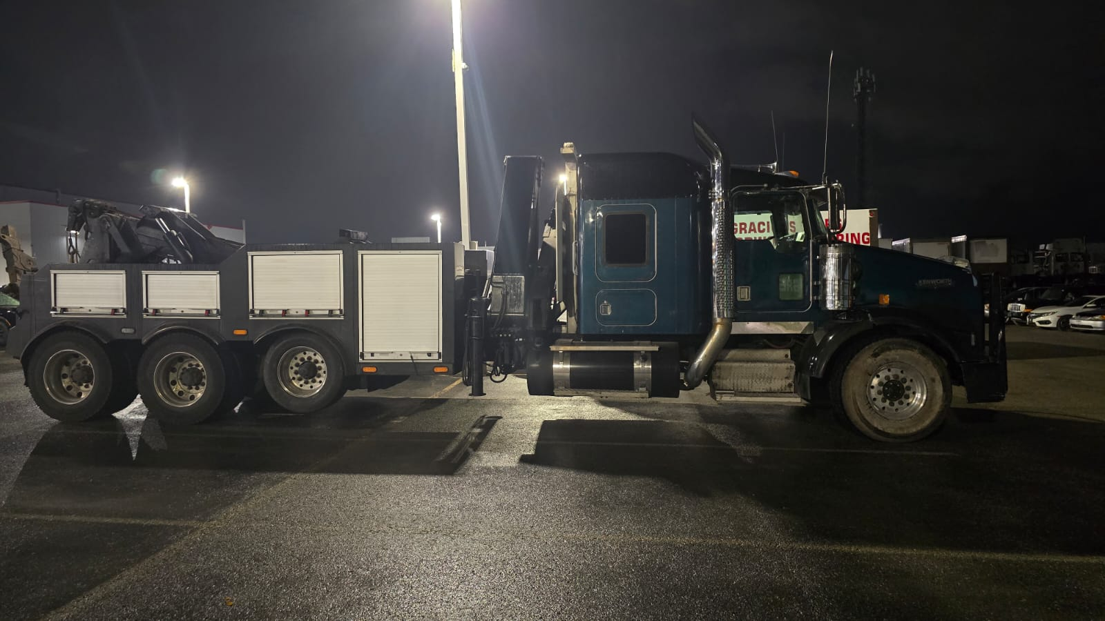 We work with safety in mind! Tow truck operator securing car to flatbed with chains