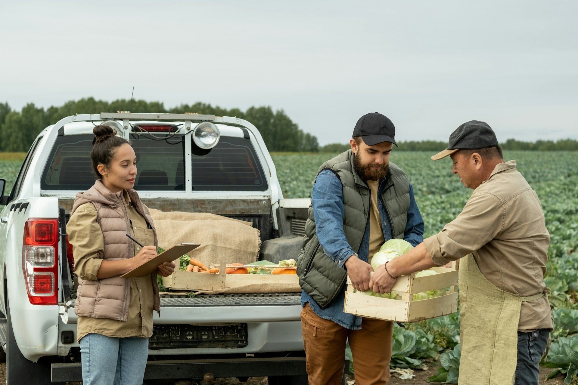 A barista taking an order from two customers at a cafe counter.