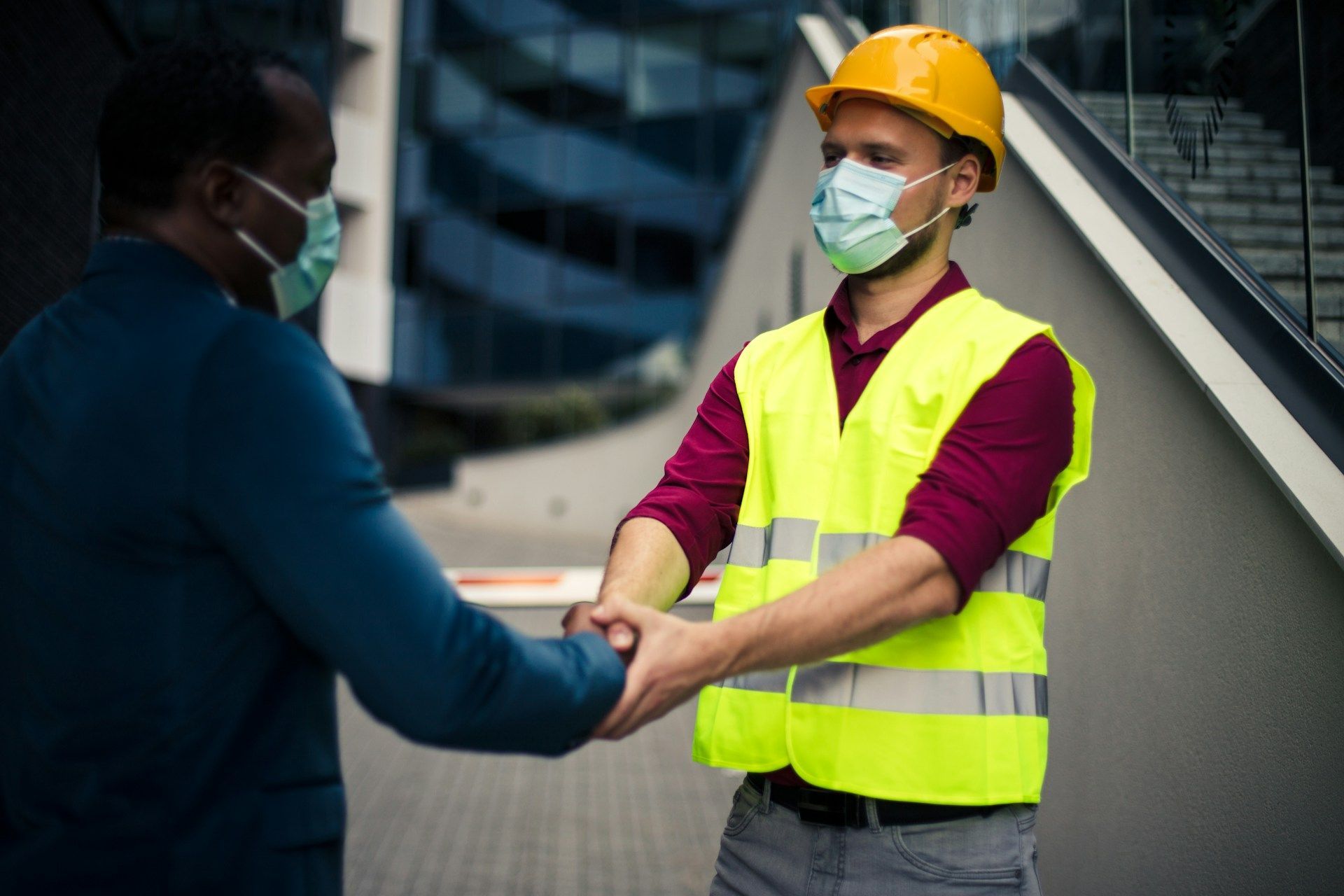 A barista taking an order from two customers at a cafe counter.