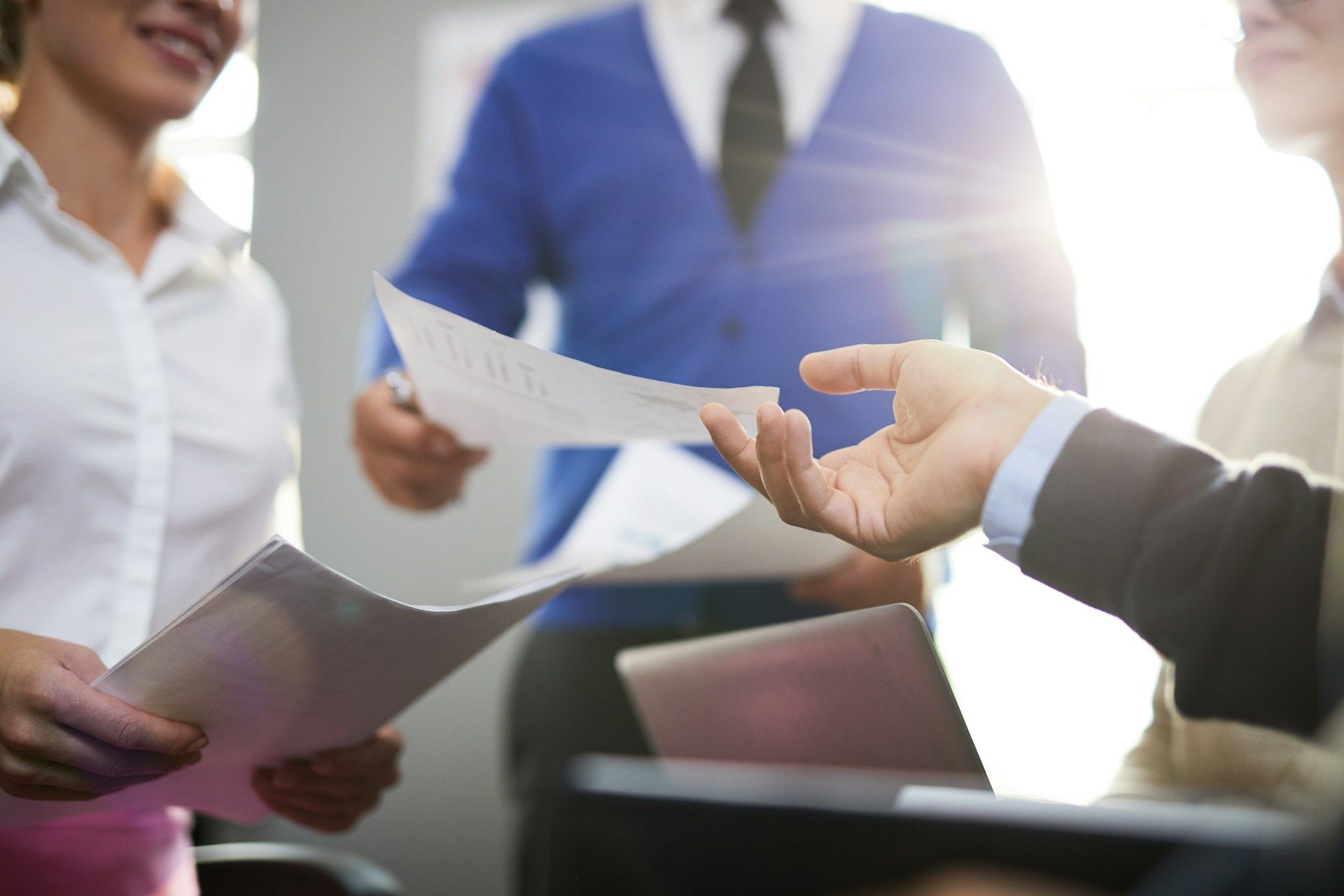 Man shows older man tablet while cooking in kitchen.