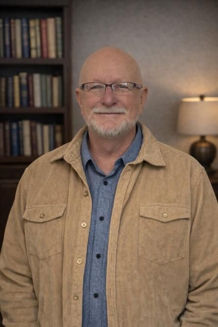 Woman in blue blazer, white shirt, looking at the viewer; cityscape in the background.