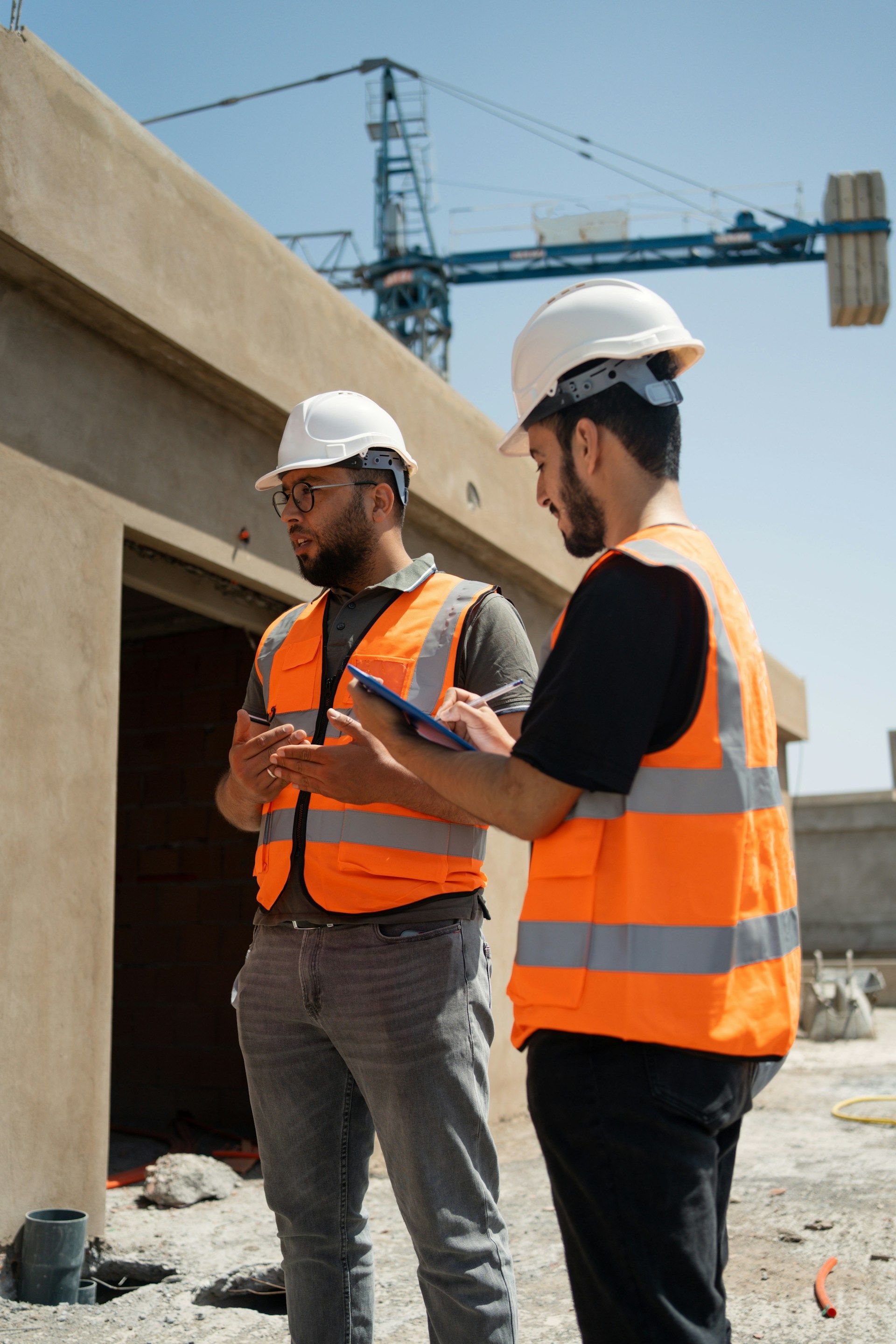 Family of three looking at a laptop on the floor; smiling faces and neutral indoor setting.