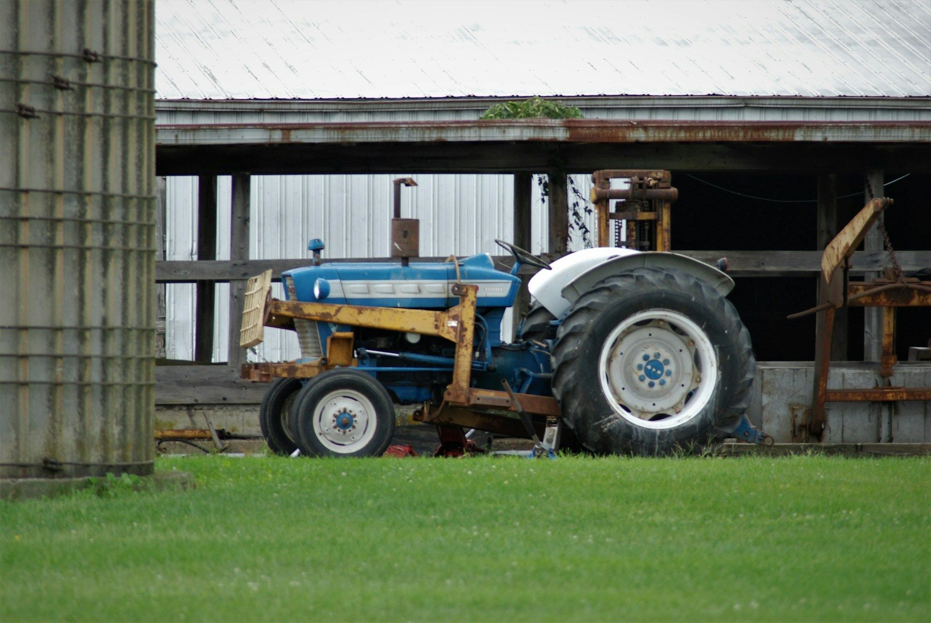 Man shows older man tablet while cooking in kitchen.
