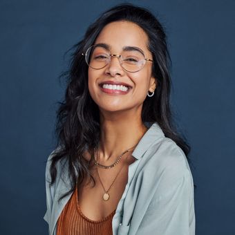 A man with a beard is wearing glasses and smiling