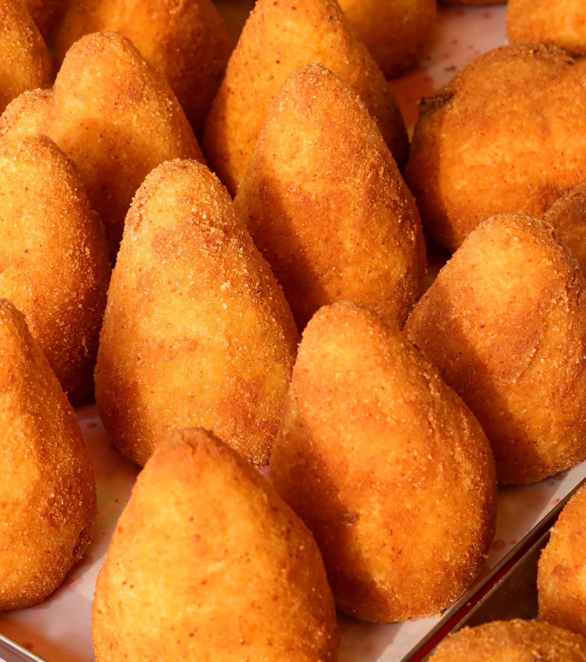 Arancini dorati a forma di cono, polpette di riso fritte tipiche dell'Italia.