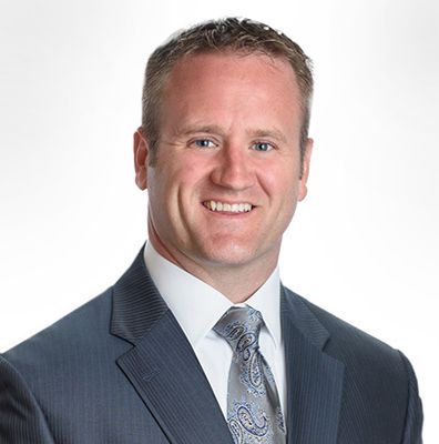 A man in a suit and tie is smiling for the camera.