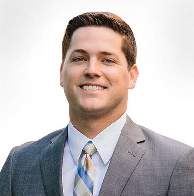 A man in a suit and tie is smiling for the camera.