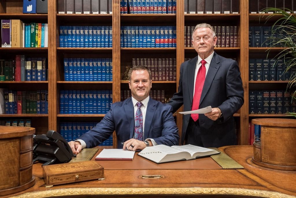 Two men in suits and ties are standing next to each other in a library.