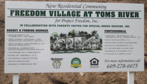 A sign for a new residential community called freedom village at toms river