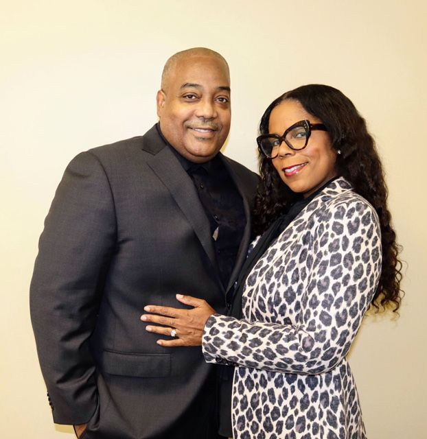 a man in a suit and a woman in a leopard print jacket are posing for a picture