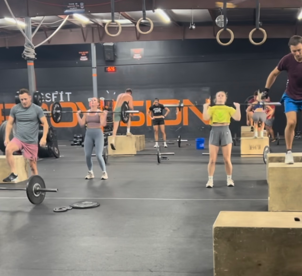 A woman is doing a pull up in a gym.