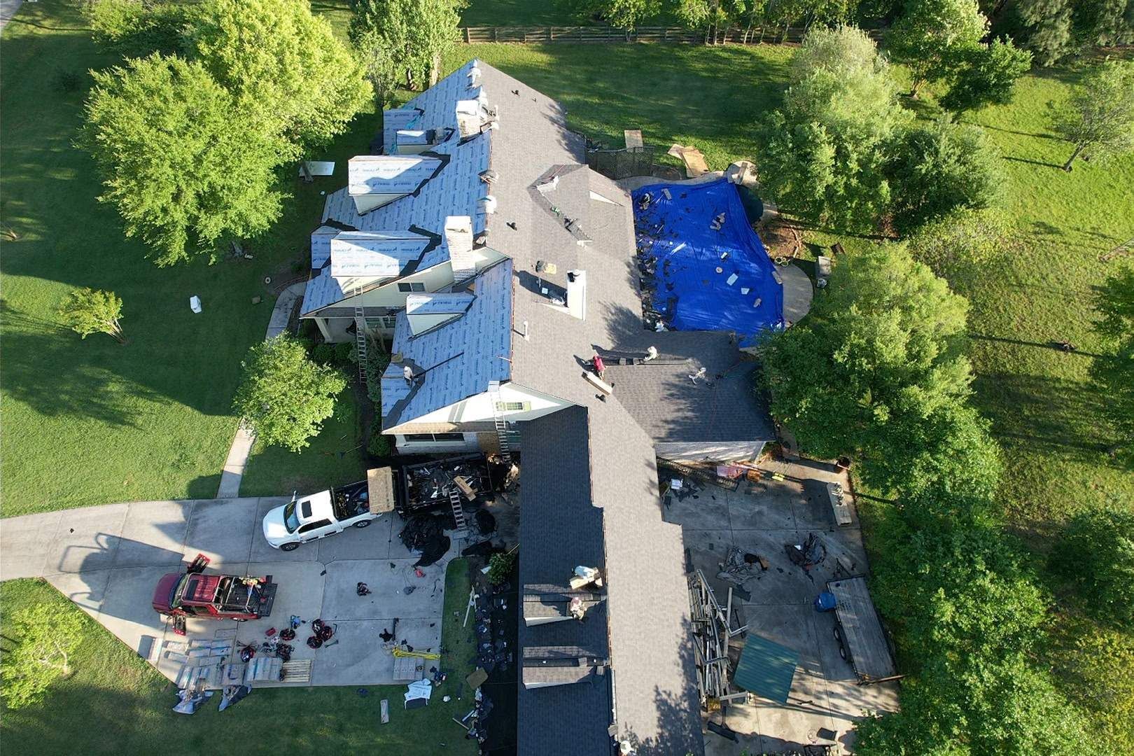 Modern house with solar panels on a gray roof, in a residential neighborhood.