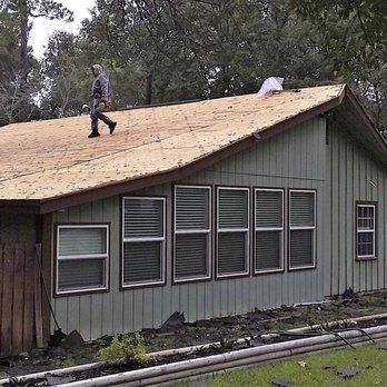 Person on a roof replacing shingles of a green house.