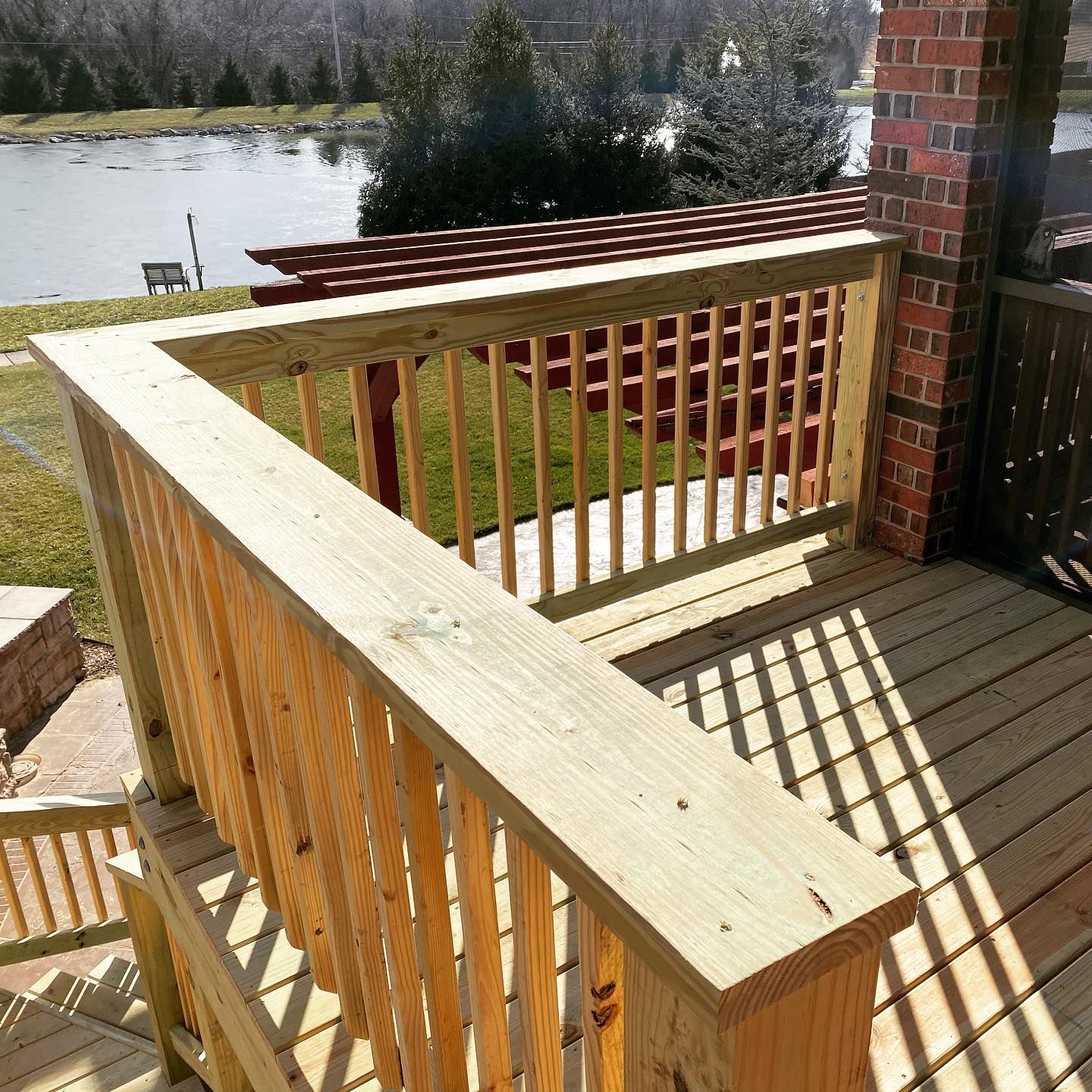 A wooden deck with a view of a lake