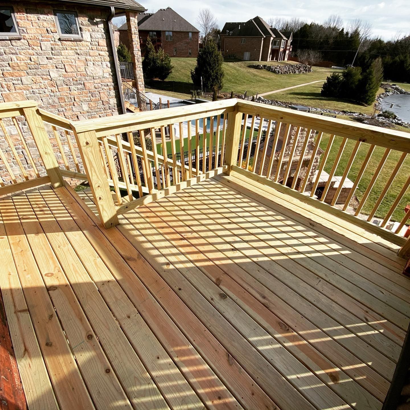 A wooden deck with a brick building in the background