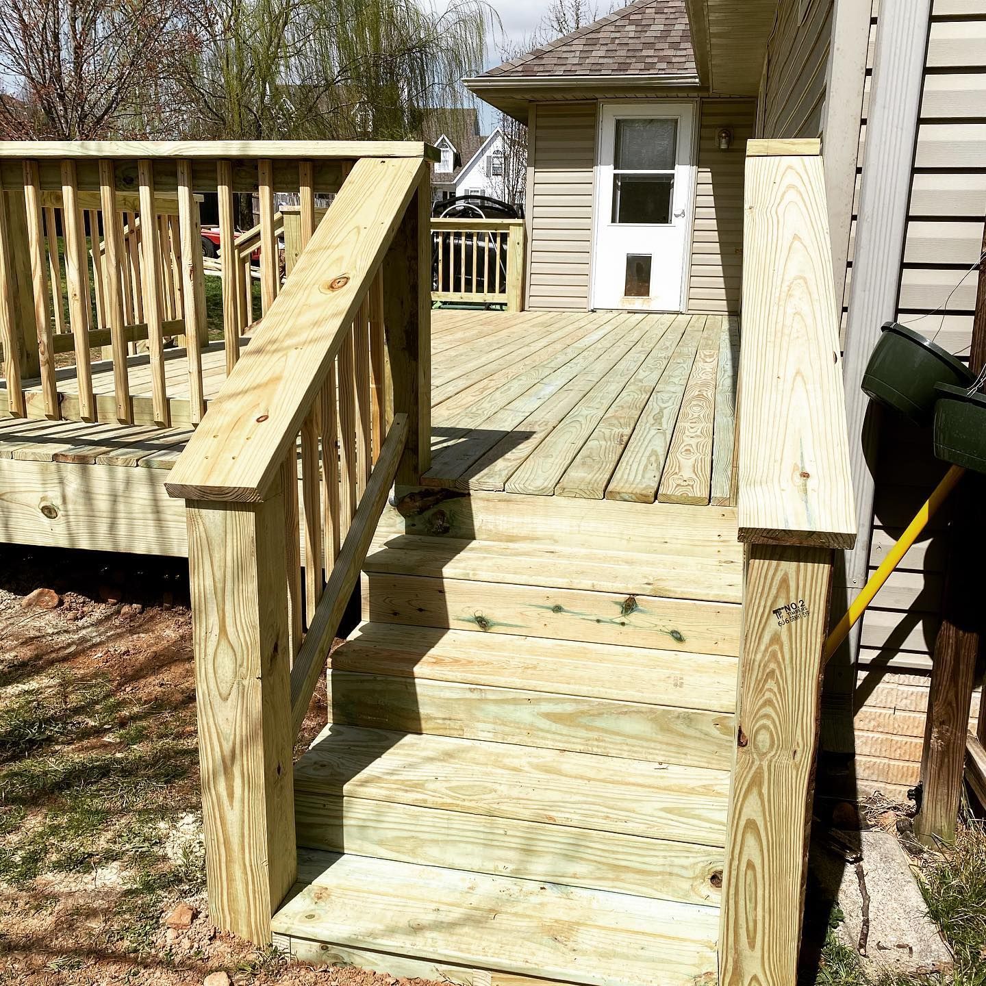 A wooden deck with stairs leading up to a house.