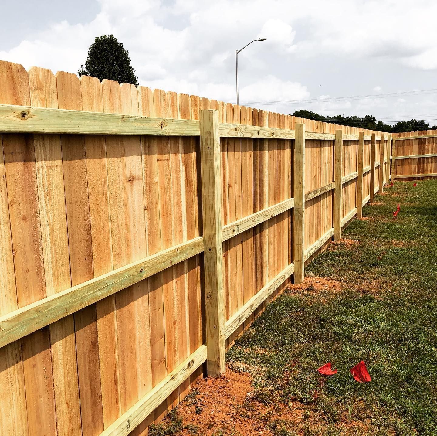 A wooden fence is sitting in the middle of a grassy field.