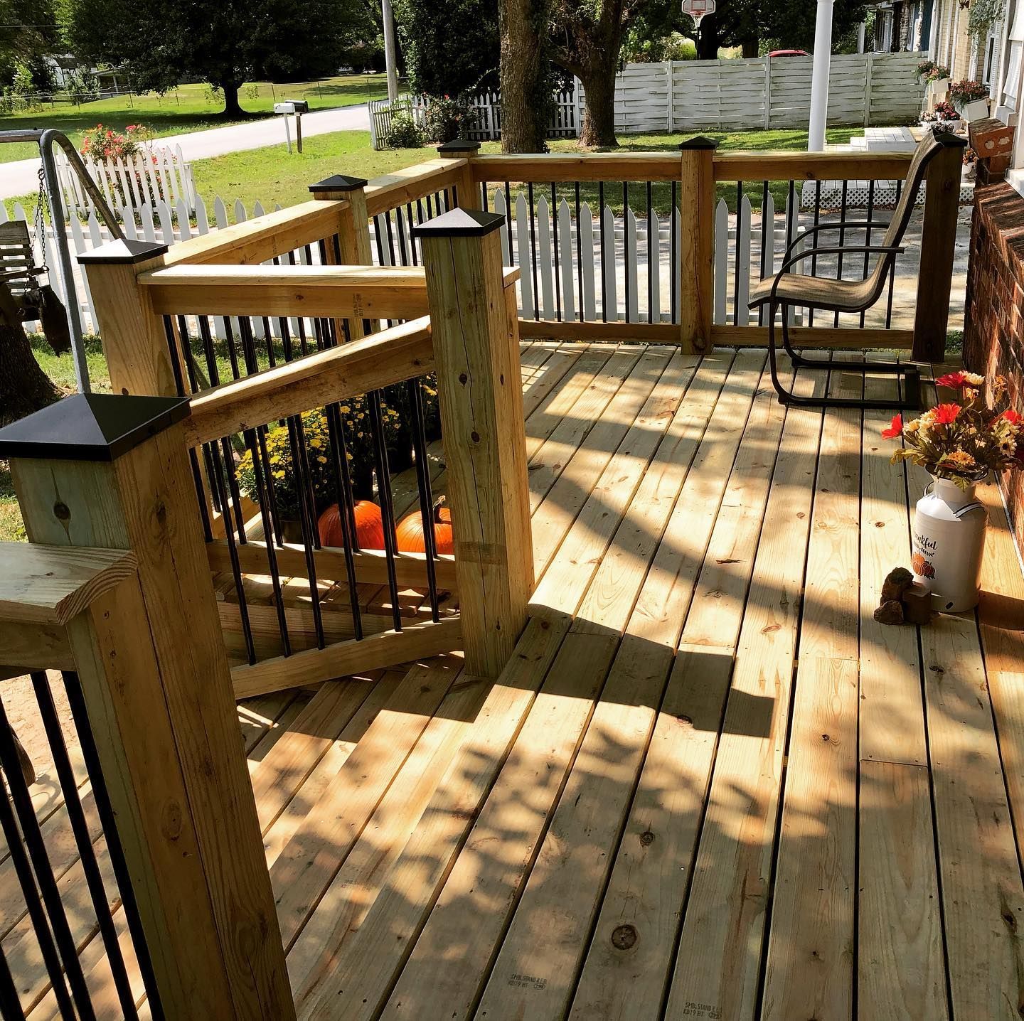 A wooden deck with a rocking chair on it
