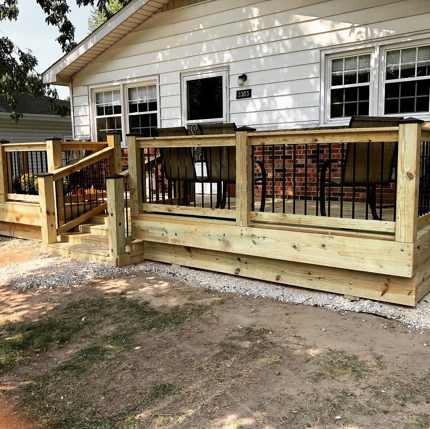 A white house with a wooden deck in front of it