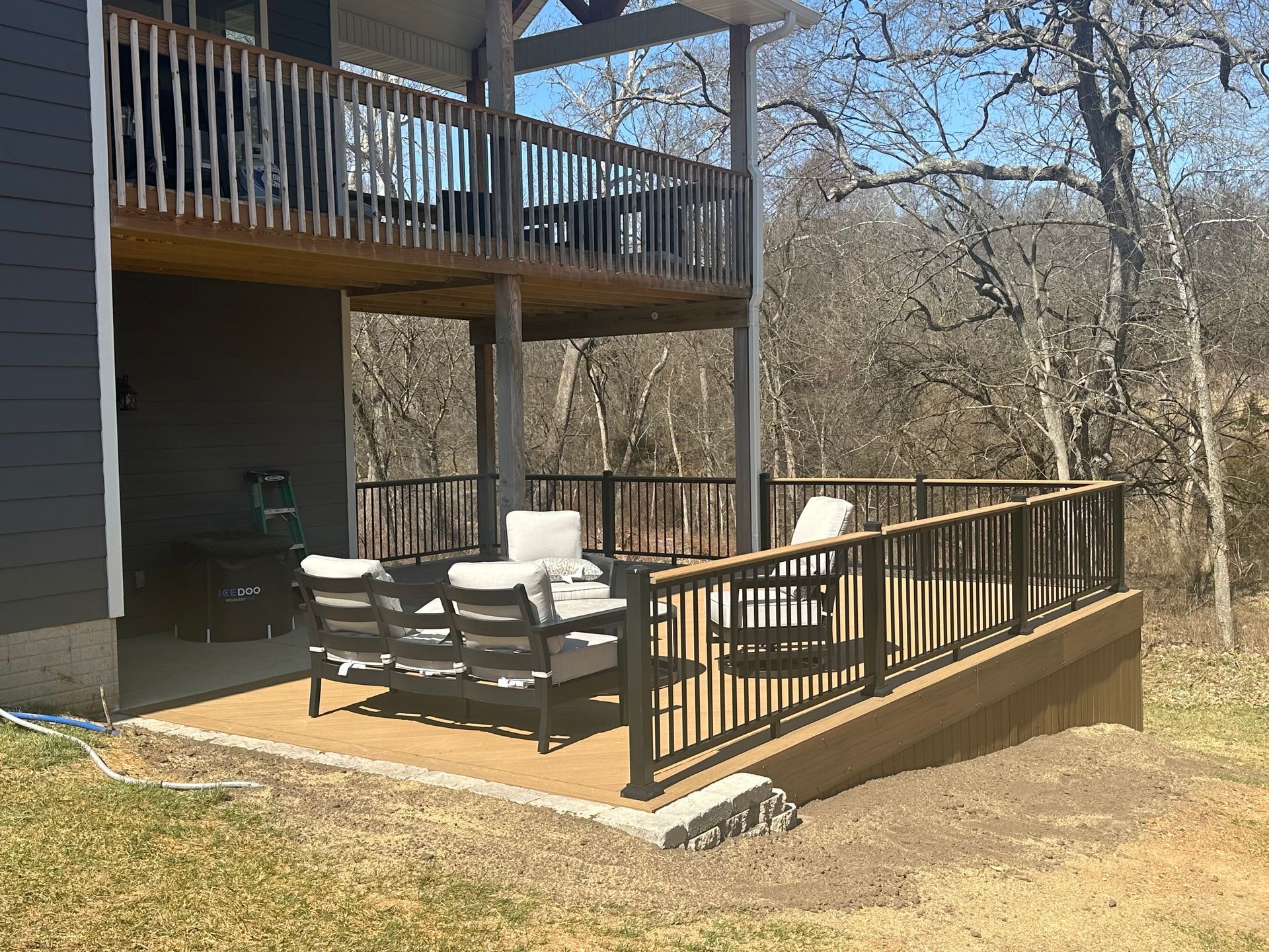 A patio with wicker furniture and a stone fireplace