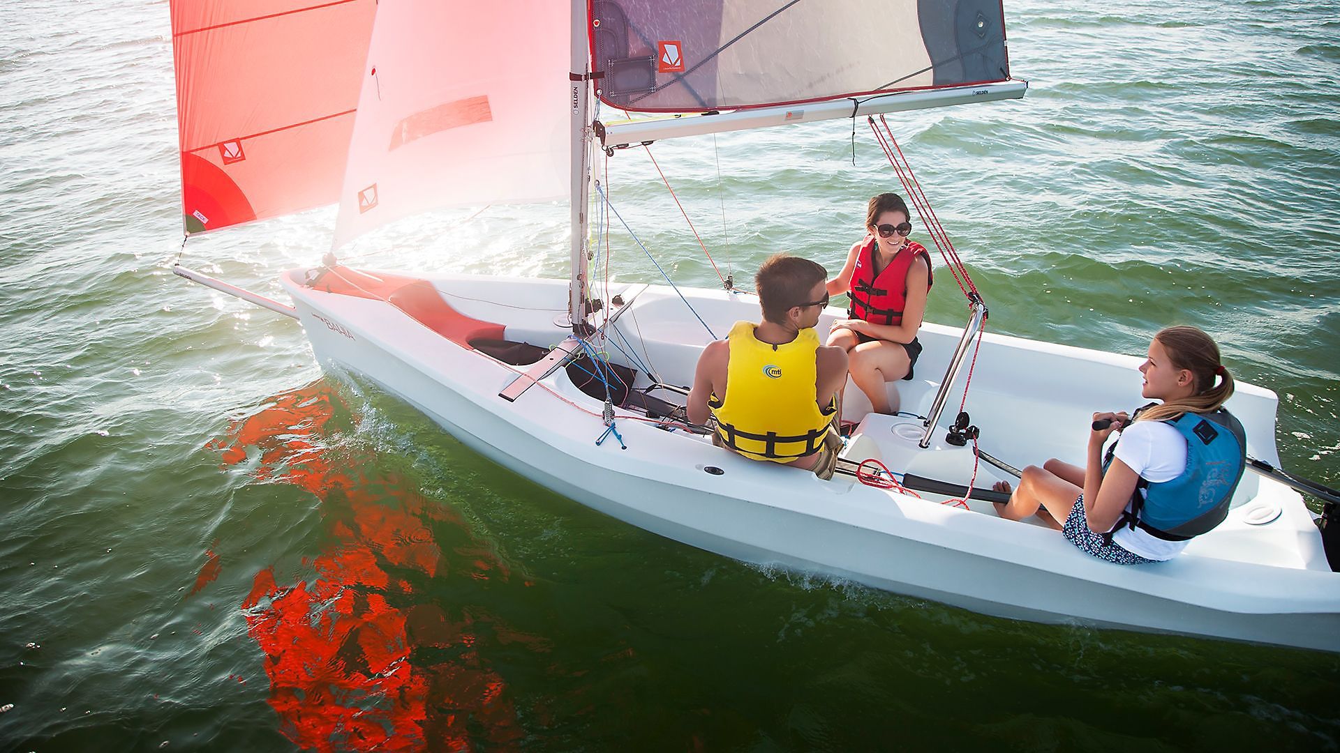 A group of people are sailing a small boat in the water.