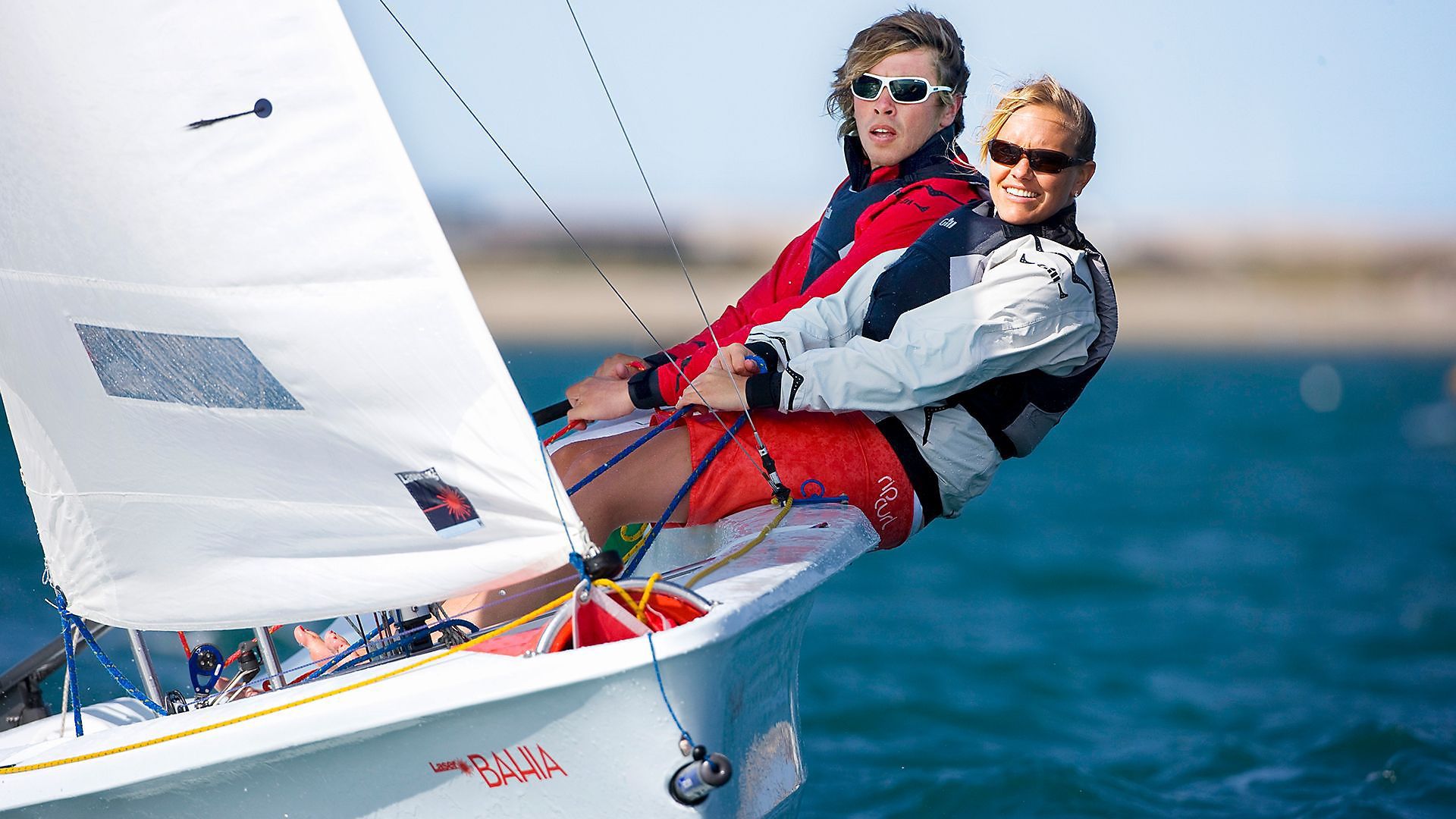 Two people are sailing a small boat in the ocean