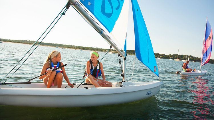 A group of people are sailing boats on a lake