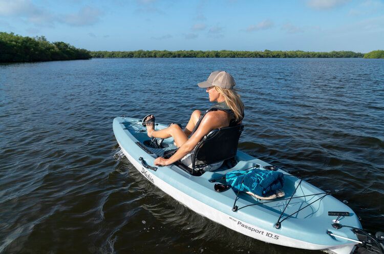 A woman is sitting in a kayak on a lake.