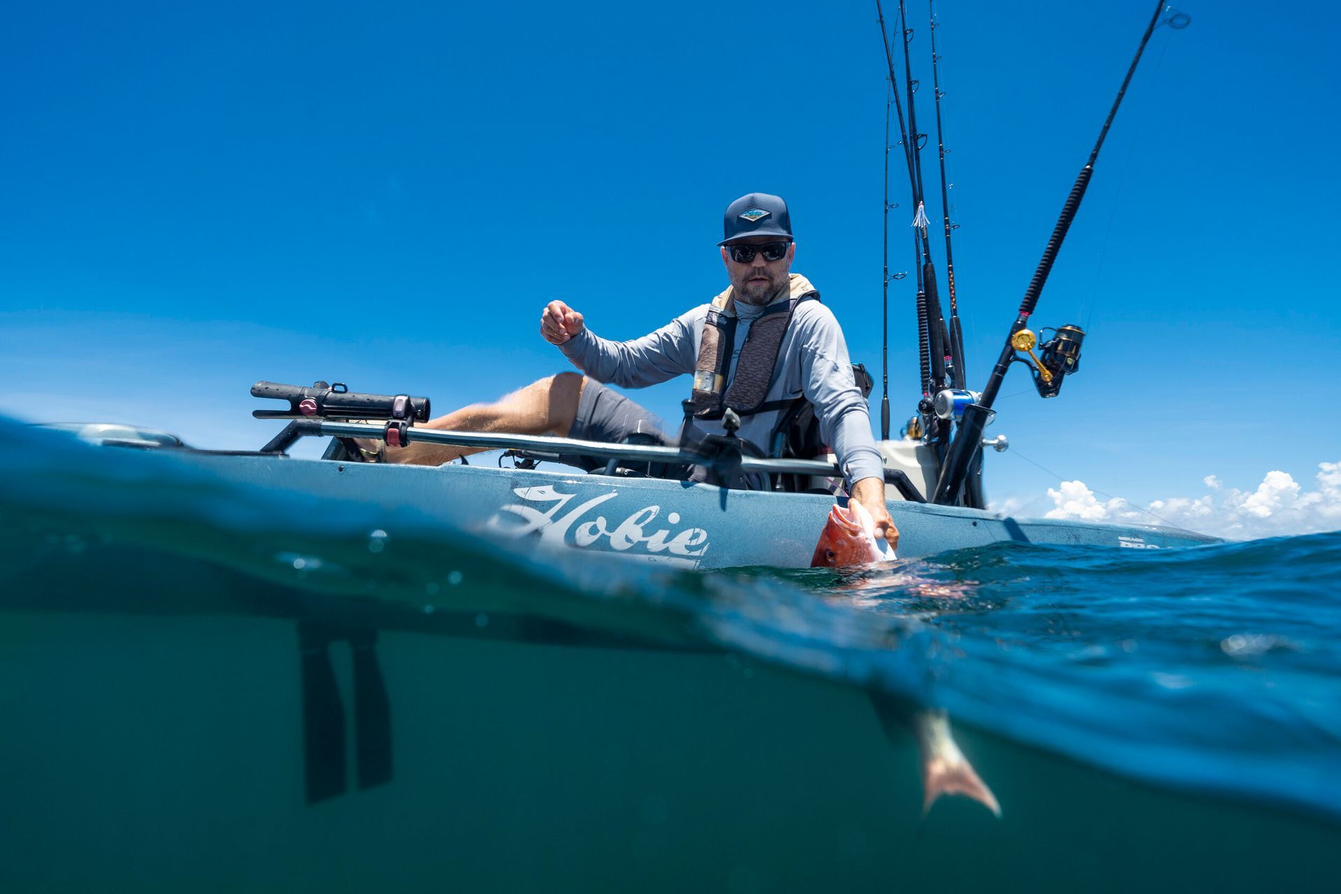 A man is fishing in a kayak in the ocean.