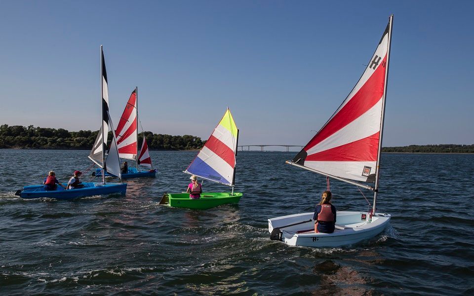 A group of people are sailing boats on a lake.