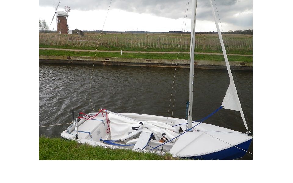 A small sailboat with a windmill in the background