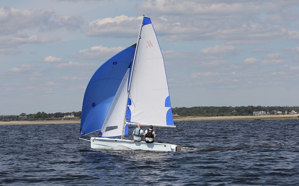 A sailboat with a blue sail is floating on the water