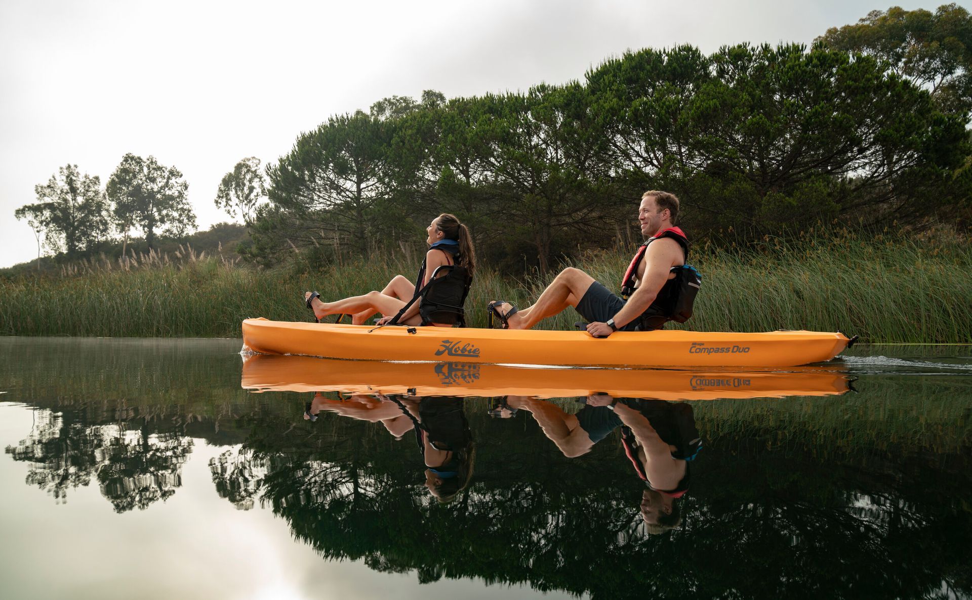 A man and a woman are sitting in a kayak on a lake