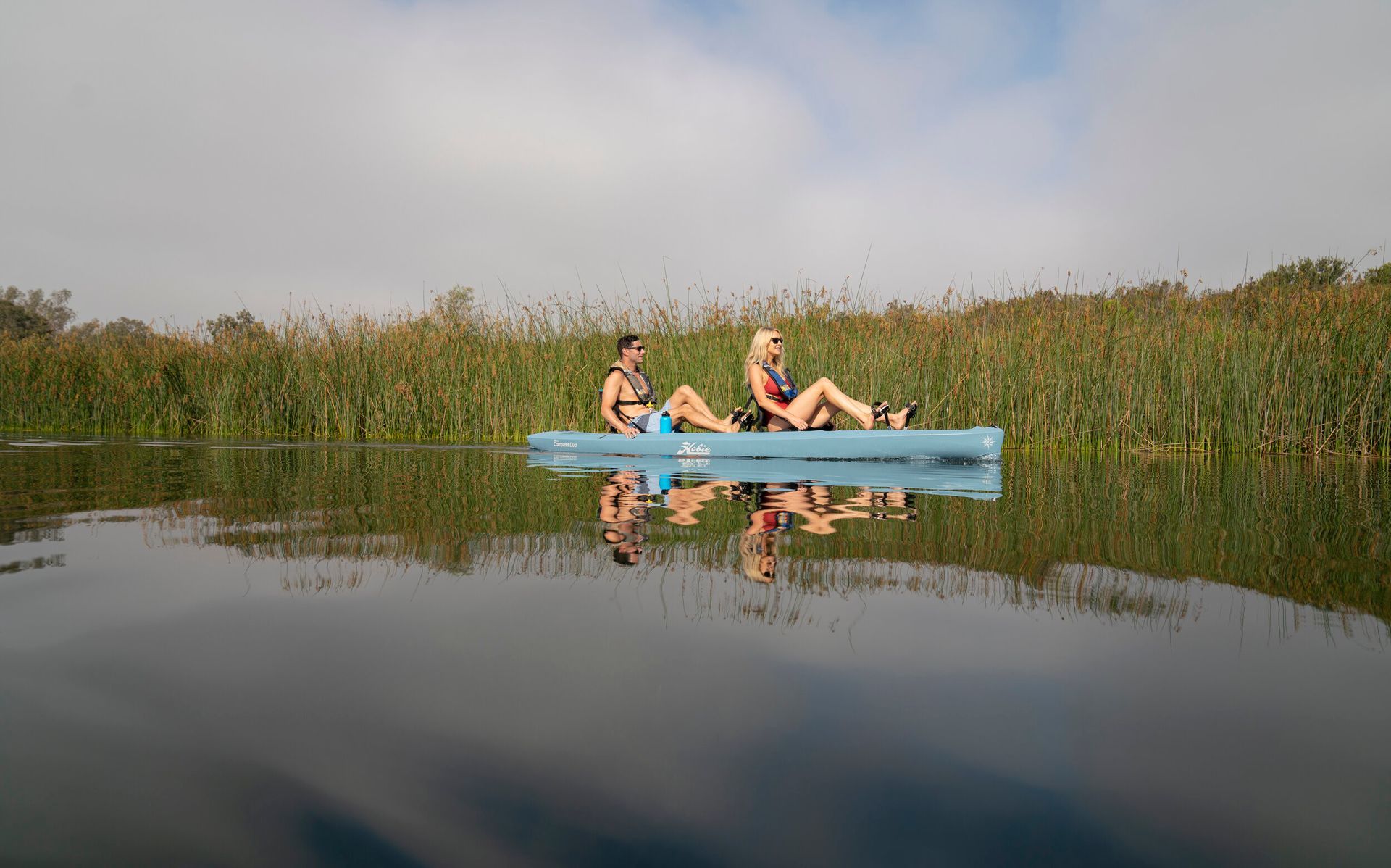 Two people are sitting in a kayak on a lake.
