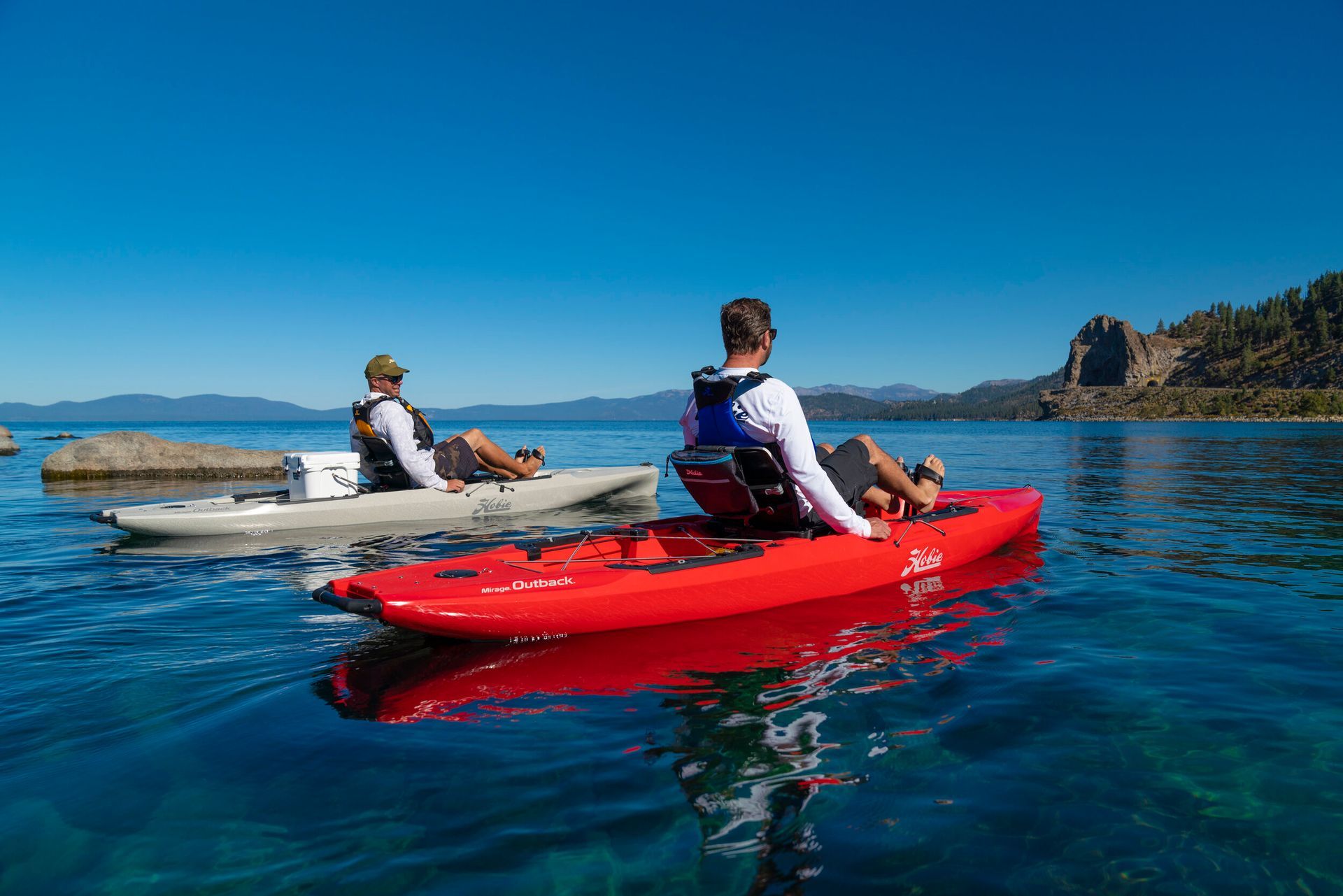 Two people are riding kayaks on a lake.