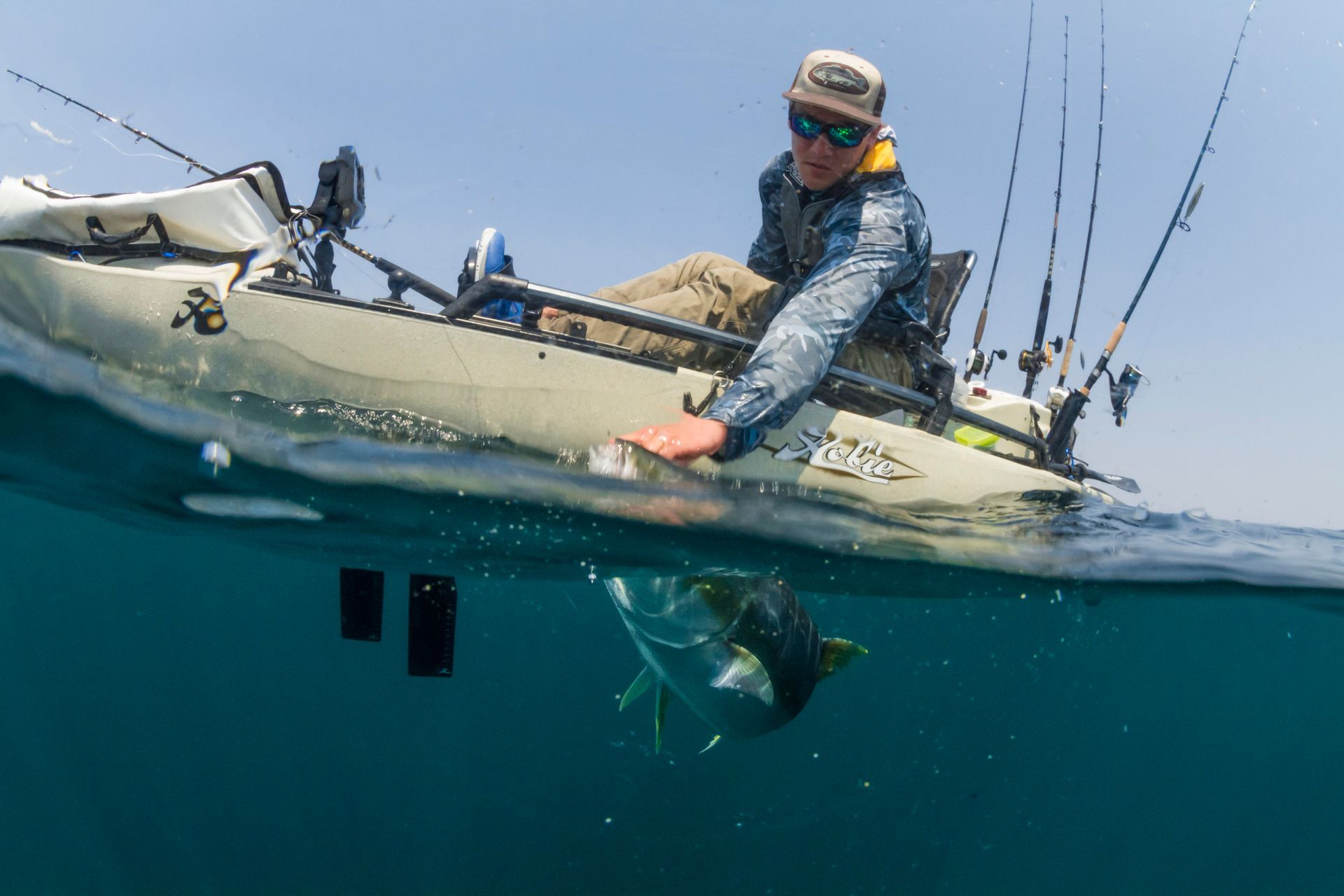 A man is fishing in a kayak in the ocean.