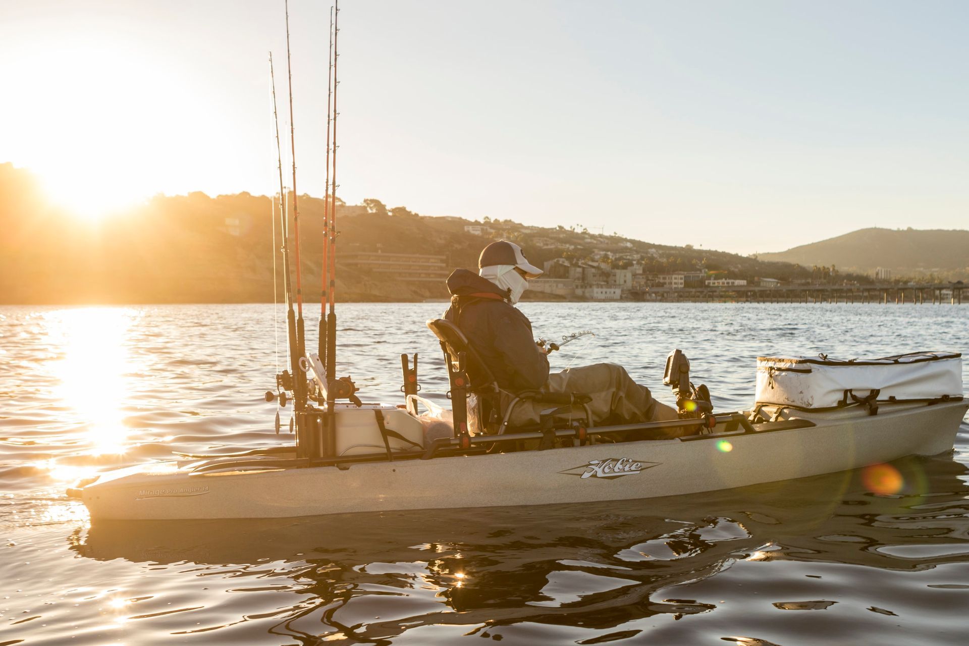 A man is sitting in a kayak on a lake.