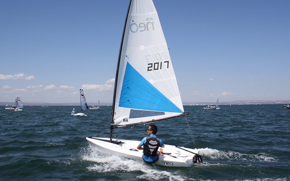 A man is sailing a small sailboat with the year 2017 on the sail