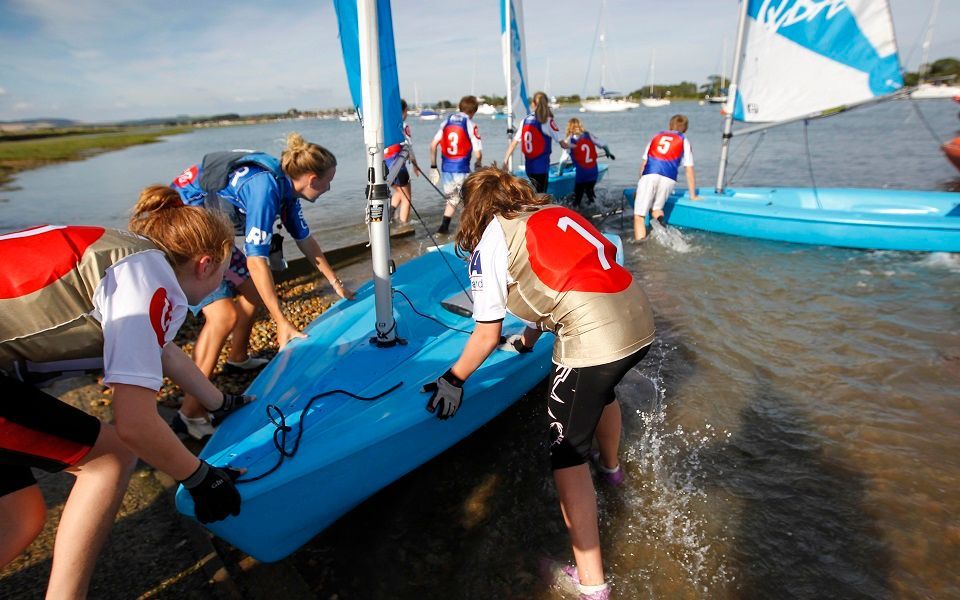 A group of people are getting ready to sail a boat