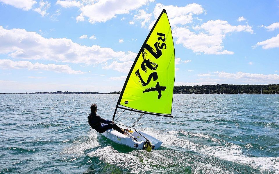 A man is sailing a small sailboat in the ocean.