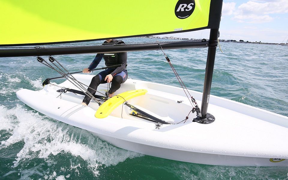 A person is riding a sailboat in the ocean.