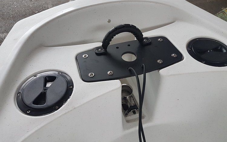 A white boat with black speakers and a black handle