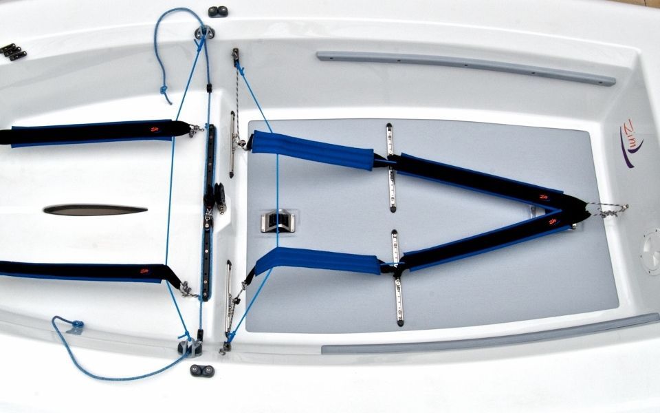 A white boat with a blue cushion on the floor