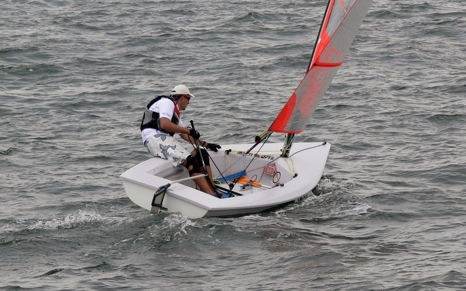 A man is sailing a small boat in the ocean.