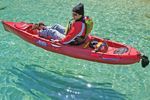 A man is sitting in a red kayak in the water.