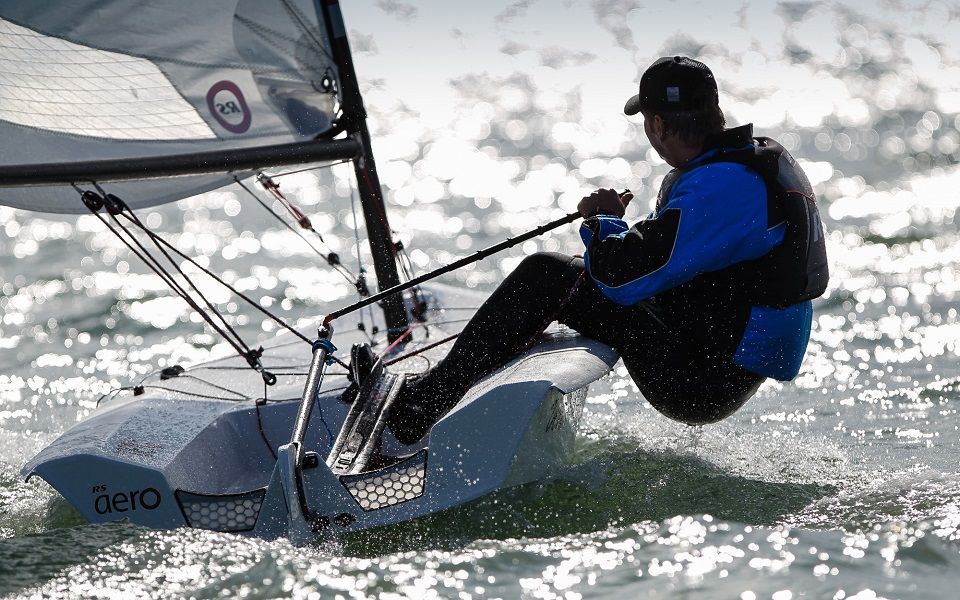 A man is sailing a small sailboat in the ocean