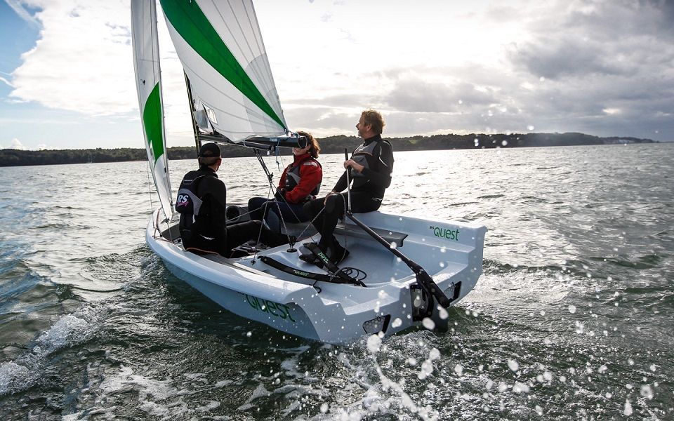 A group of people are sitting on a sailboat in the water.